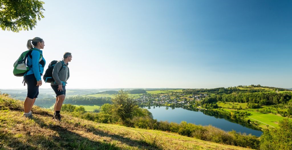 Wanderer blicken auf das Schalkenmehrener Maar