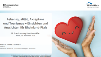 Titel Prof. Eisenstein, Nov. 23_334 breit Präsentationsfolie zur Studie „Lebensqualität, Akzeptanz und Tourismus – Einsichten und Aussichten für Rheinland-Pfalz“ mit rotem Herzsymbol in Händen.
