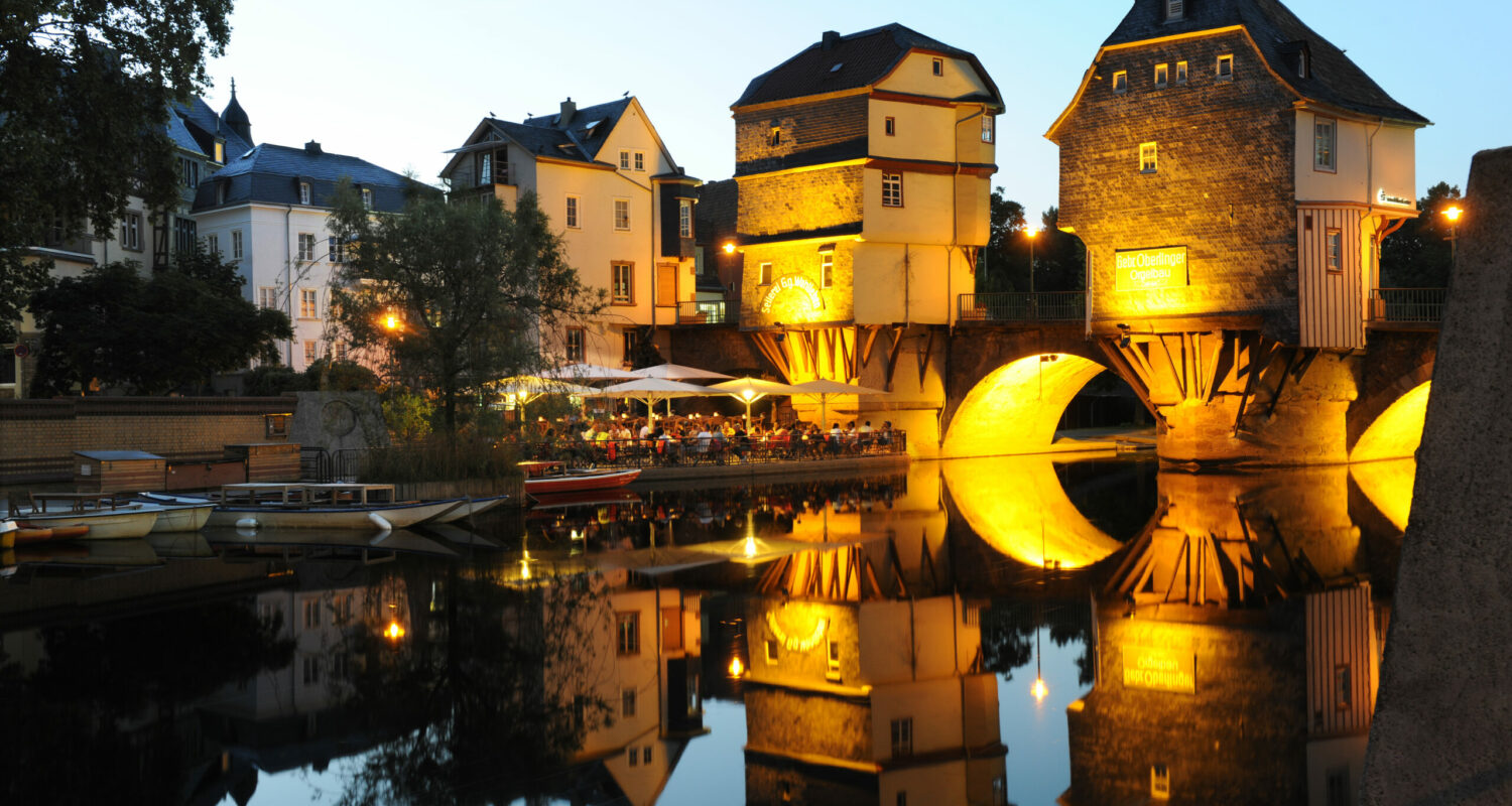 Beleuchtete Brückenhäuser in Bad Kreuznach am Abend Die auf den Pfeilern der Alten Nahebrücke errichteten Brückenhäuser zählen zu den Wahrzeichen Bad Kreuznachs und wurden zwischen 1500 und 1600 als seltene Form der Brückenarchitektur errichtet. Zusammen mit der benachbarten Pauluskirche und dem Mühlenteich bilden sie ein wunderschönes Ensemble, das zum Verweilen einlädt.