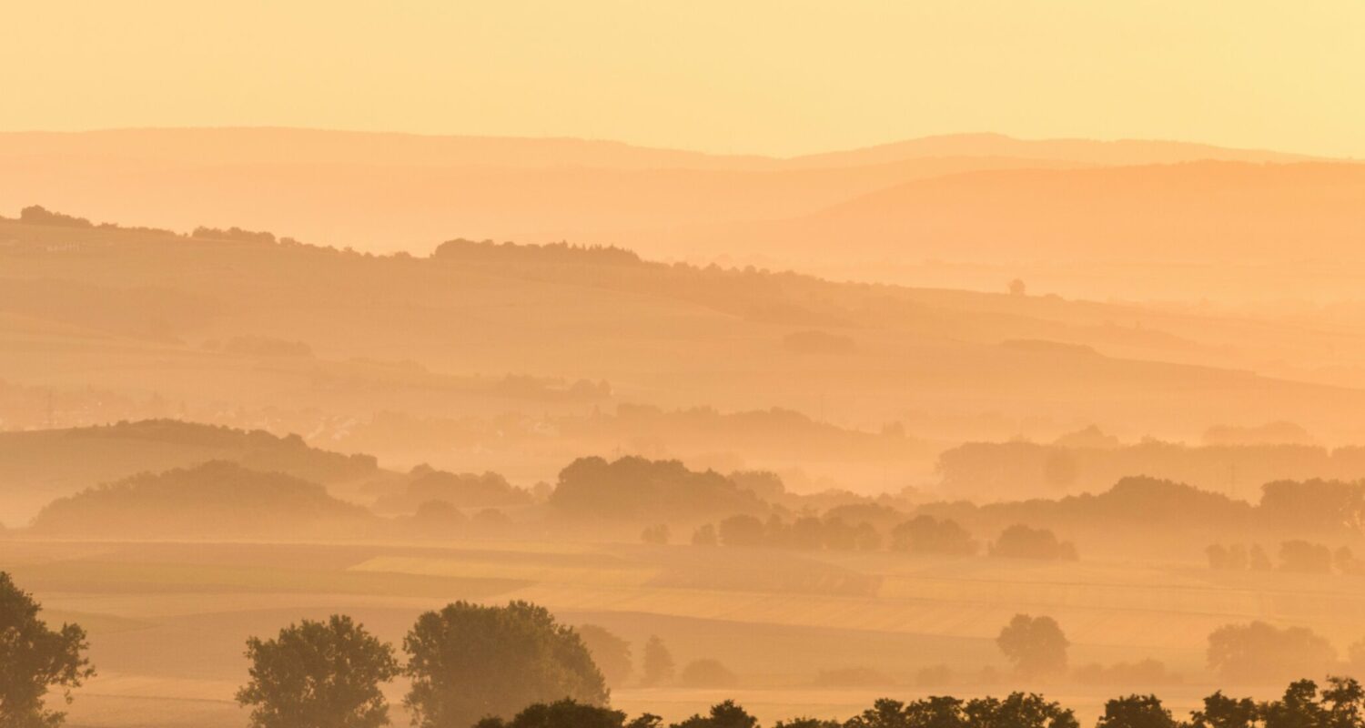 Landschaft bei Mayen im Morgendunst, Titelmotiv der Tourismusstrategie Rheinland-Pfalz 2025