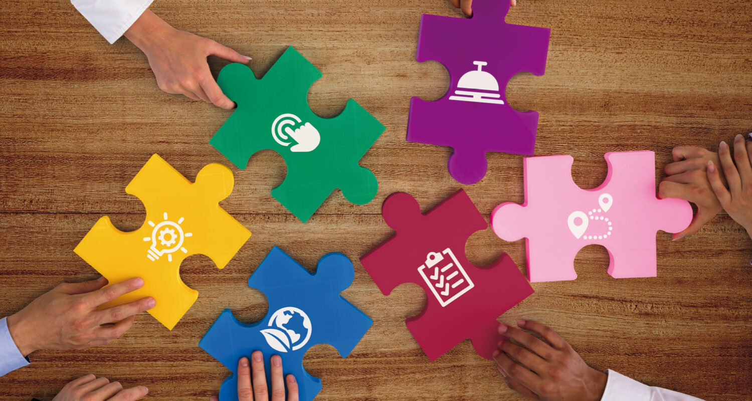 Hände mit 6 bunten Puzzleteilen, die als Icons die 6 Handlungsfelder symbolisieren​